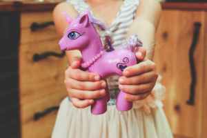 child holding unicorn toy